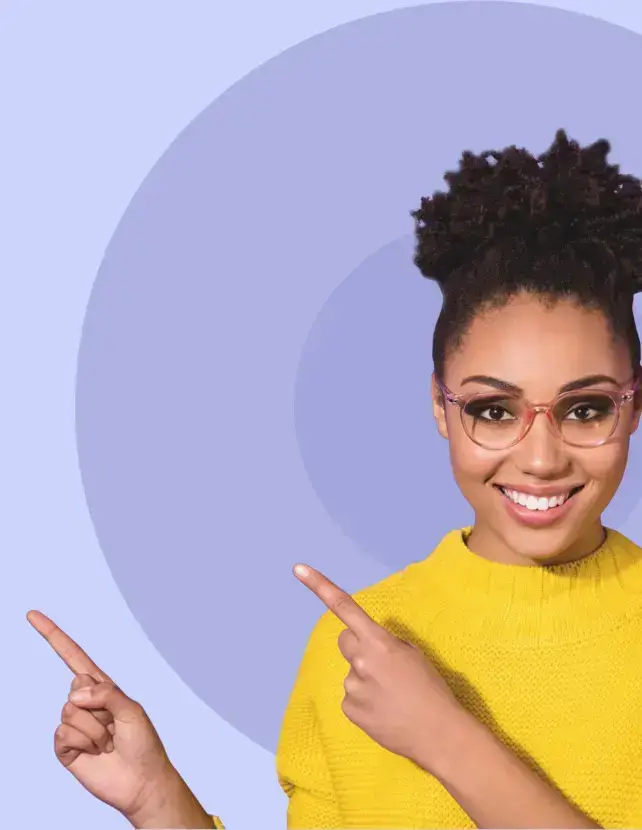 Smiling woman with glasses and curly hair wearing a yellow sweater, standing in front of a purple background with concentric circles, pointing with both hands to the left.